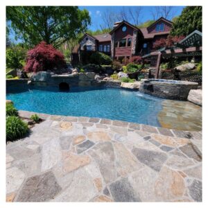 A swimming pool located at the back of a house, with custom stone walkways, gazebos, and landscaping.