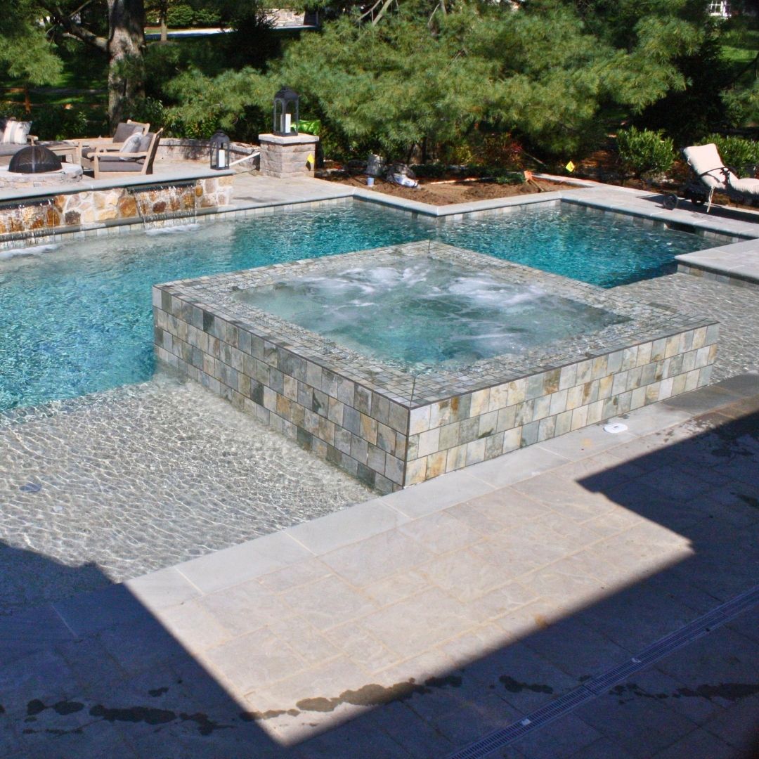 Raised square tiled spa integrated into a swimming pool