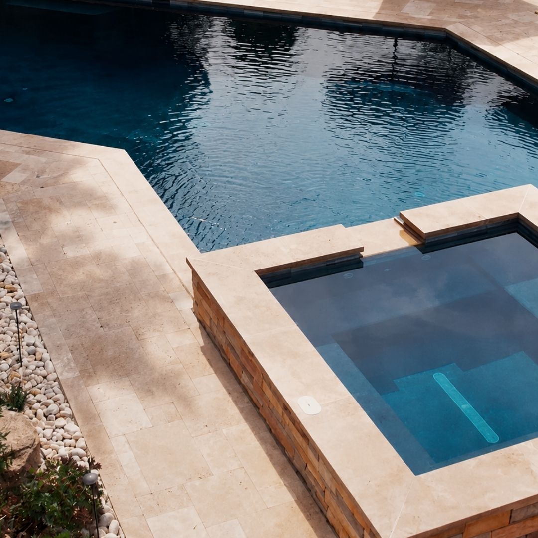 Aerial view of dark blue pool and raised stone spa.